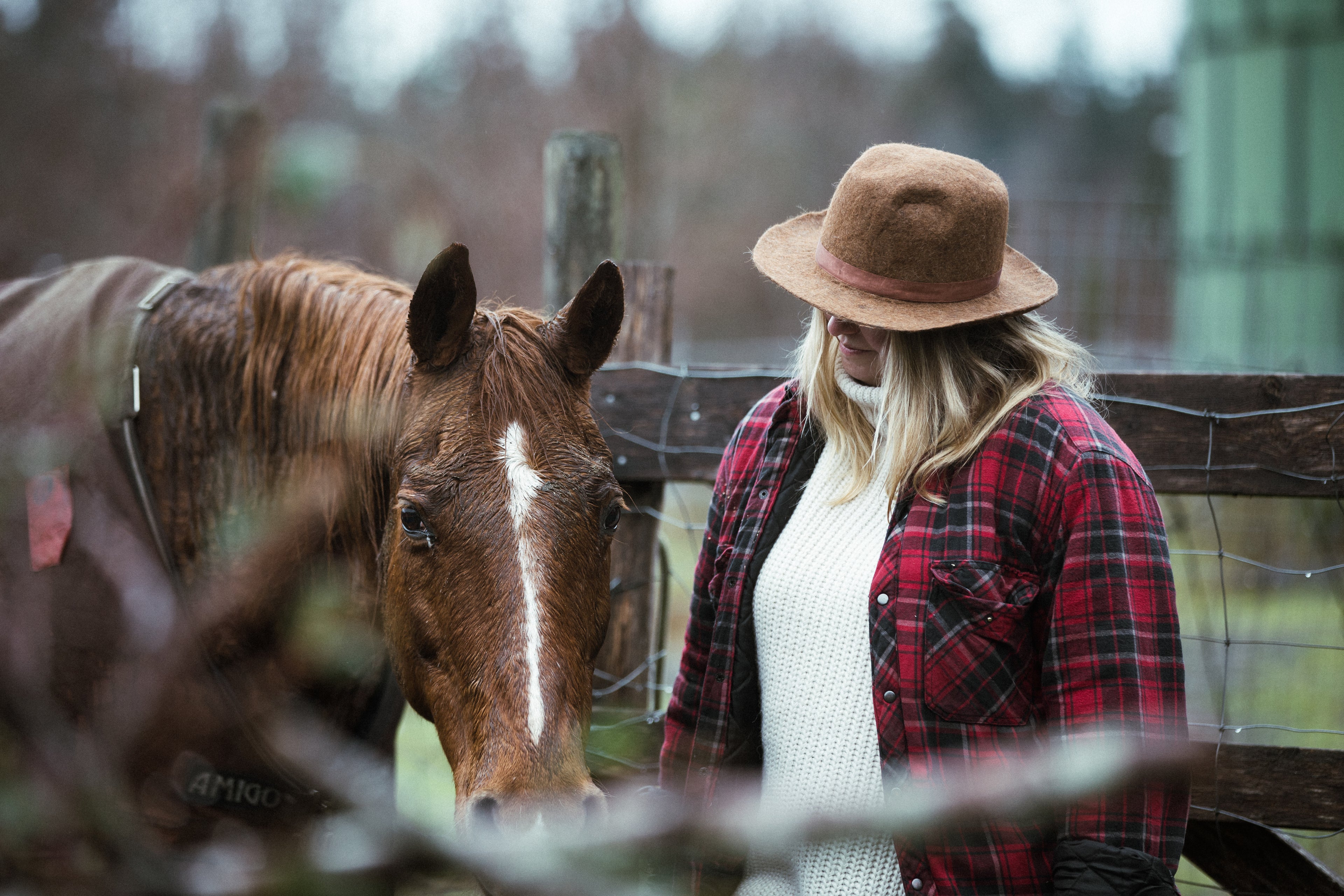 Woman standing with horse on a farm